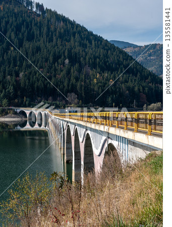 Scenic Arched Viaduct Crossing Lake Izvorul Muntelui In Romanian Mountains 135581441