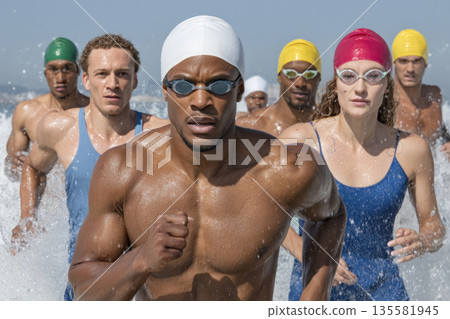 Athlete water swimwear competition running ocean group determination energy action Swimmers colorful swimwear run from ocean water showing 135581945
