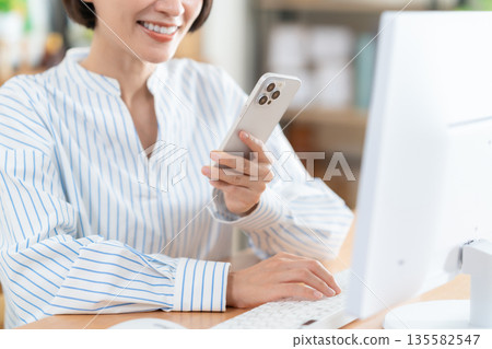 在客廳裡的中年女子遠程辦公 135582547