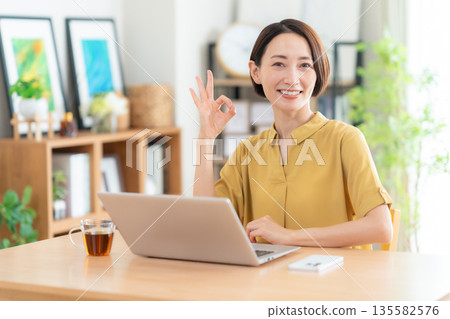 中年婦女在客廳看電腦 135582576