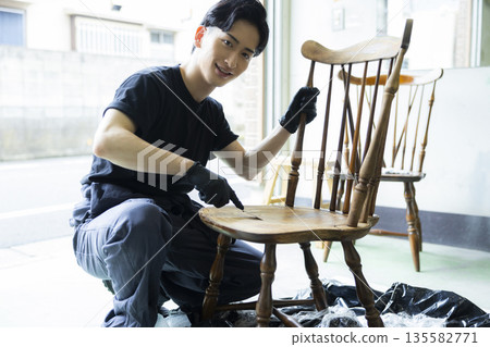 Man painting a chair Man painting a chair 135582771