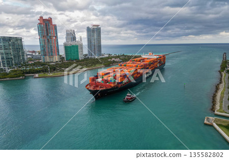 Miami, Florida, USA - January 16, 2025: Freight container on cargo vessel. Cargo ship vessel. Miami port. Container ship. Cargo Hapag Lloyd ship with container stormy sea, aerial view. Bremen express 135582802