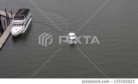 Vancouver, Canada - May 29, 2019: False Creek boat tour. Touristic boat at sea, Granville island. Inflatable sea boat tourism. Travel concept. Touristic boat sailing at sea, aerial top view Vancouver, Canada - May 29, 2019: False Creek boat tour. Touristic boat at sea, Granville island. Inflatable sea boat tourism. Travel concept. Touristic boat sailing at sea, aerial top view 135582823