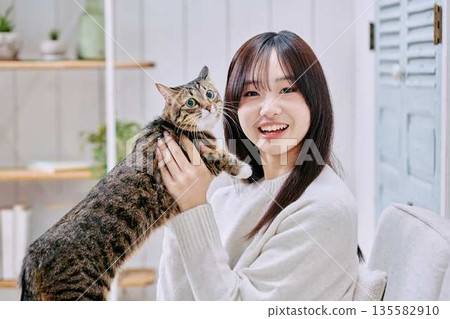 一位微笑的日本女子抱著一隻貓 135582910