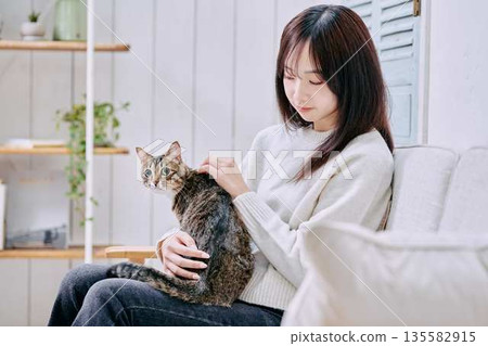一位微笑的日本女子抱著一隻貓 一位微笑的日本女子抱著一隻貓 135582915