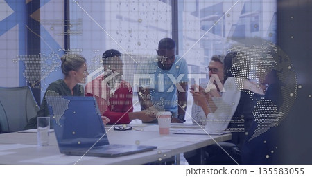 Professionals in business attire discussing data at table in boardroom, with laptop and coffee cup 135583055