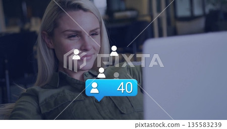 Woman in olive-green shirt examining laptop in work lounge with avatars and blue bubble showing 40 Woman in olive-green shirt examining laptop in work lounge with avatars and blue bubble showing 40 135583239