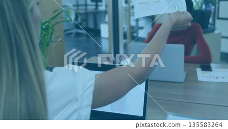 Handing woman with long braids extending printed chart across desk in open-plan office, copy space Handing woman with long braids extending printed chart across desk in open-plan office, copy space 135583264