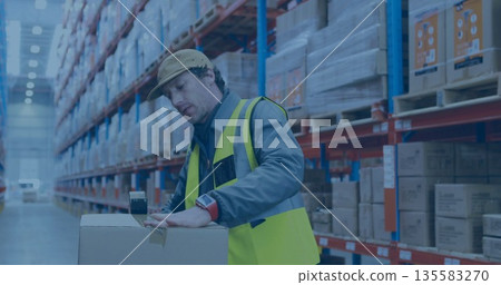 Using handheld scanner warehouse worker scanning label on pallet of boxes at distribution center 135583270