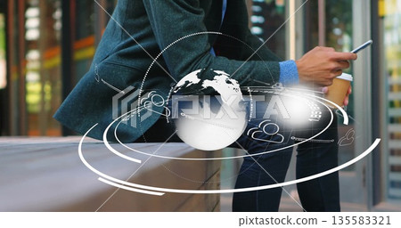 Sitting man wearing blazer holding coffee cup, tapping smartphone on plaza bench with network icons 135583321