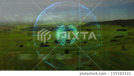 Rotating holographic Earth globe over rural farmland, with concentric rings and text overlays 135583322