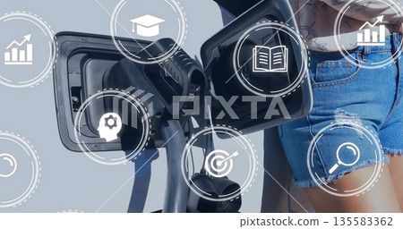 Woman in denim shorts plugging ebike connector into port outdoors showing overlay icons 135583362