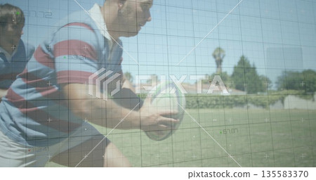 Charging rugby player in striped jersey gripping rugby ball and driving forward on suburban field Charging rugby player in striped jersey gripping rugby ball and driving forward on suburban field 135583370