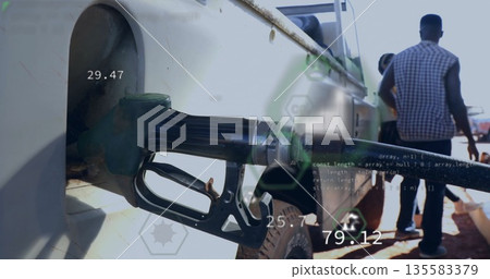 Inserting green fuel nozzle into truck fill port at gas station, with digital readouts, copy space 135583379