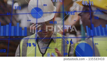 Checking handheld device, worker in white hard hat inspecting warehouse shelves, with data overlays Checking handheld device, worker in white hard hat inspecting warehouse shelves, with data overlays 135583410