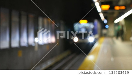 Approaching subway train moving into underground platform, with headlights and yellow safety line Approaching subway train moving into underground platform, with headlights and yellow safety line 135583419