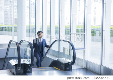 Escalator and businessman Escalator and businessman 135583540