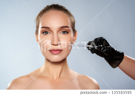 Woman receiving facial treatment in clinic during daytime with medical professional Woman receiving facial treatment in clinic during daytime with medical professional 135583595