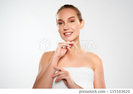 Woman smiling and showing hands while posing for a studio session with a neutral background Woman smiling and showing hands while posing for a studio session with a neutral background 135583620