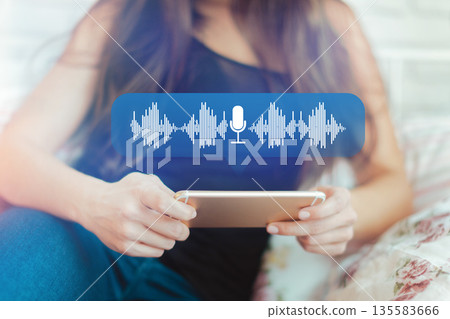 Person using smartphone for voice recording in a home setting during the day Person using smartphone for voice recording in a home setting during the day 135583666