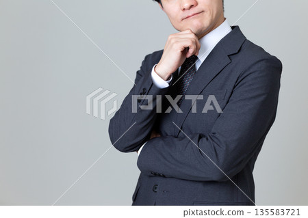 一位身穿西裝的中年男性商人,他憂心忡忡。 一位身穿西裝的中年男性商人,他憂心忡忡。 135583721