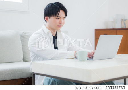 A young man who operates a computer A young man who operates a computer 135583785