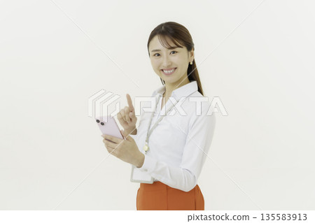 一位微笑的日本女性在白色背景上操作智慧型手機 135583913