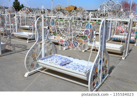 Turkmenistan. Ashkhabad market. Handmade baby cradles with colorful ornaments. 135584023