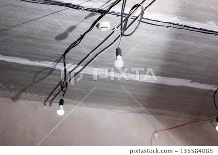 Industrial atmosphere with hanging lights and incomplete electrical installations 135584088