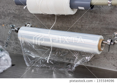 Professional kitchen station dedicated to wrapping produce and storing leftovers efficiently 135584096