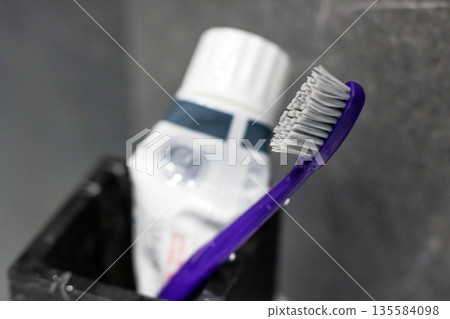 Close range shot of toothbrush and toothpaste emphasizing textures in everyday bathroom setting Close range shot of toothbrush and toothpaste emphasizing textures in everyday bathroom setting 135584098