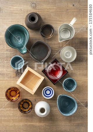 Aerial view of a wooden table background with a Japanese atmosphere, decorated with sake cups and sake cups Aerial view of a wooden table background with a Japanese atmosphere, decorated with sake cups and sake cups 135584680