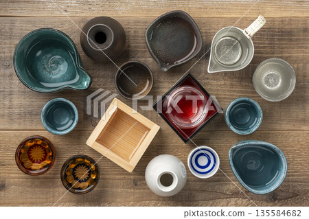 俯瞰視角，可以看到一張木桌背景，營造日式氛圍，桌上擺放著清酒杯。 135584682