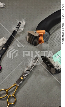 Pet grooming tools with dog fur on gray table background Pet grooming tools with dog fur on gray table background 135584721