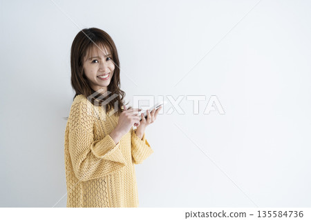 Woman using a smartphone Woman using a smartphone 135584736