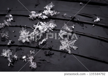 Snowflake. Macro photo of real snow crystal. Beautiful winter background seasonal nature and the weather in winter. Snowflake. Macro photo of real snow crystal. Beautiful winter background seasonal nature and the weather in winter. 135584792