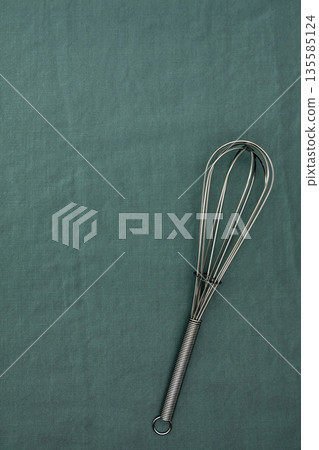 Whisk on a dark green background 135585124