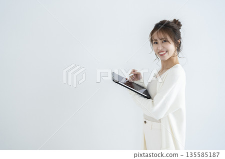 A woman who operates a tablet A woman who operates a tablet 135585187