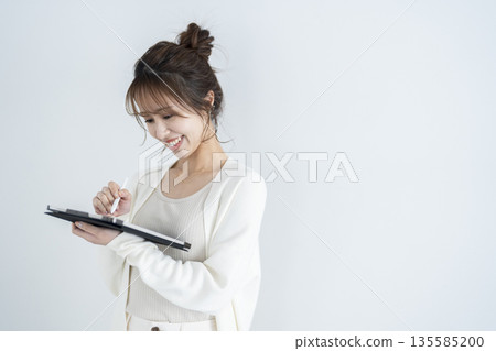 A woman who operates a tablet 135585200