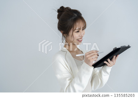 一個操作平板電腦的女人 135585203