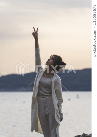 A woman walking along the beach 135585675