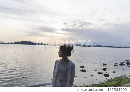 A woman walking along the beach 135585693