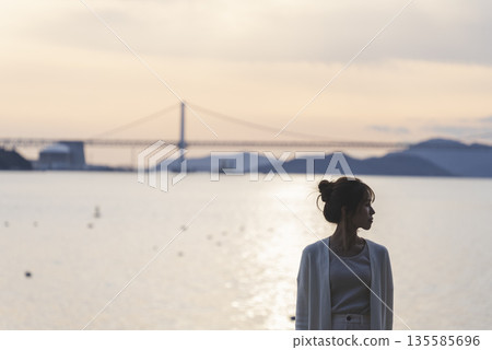 A woman walking along the beach A woman walking along the beach 135585696