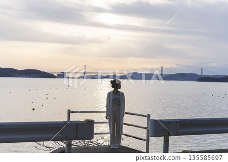 A woman walking along the beach A woman walking along the beach 135585697