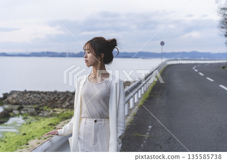 A woman walking along the beach 135585738