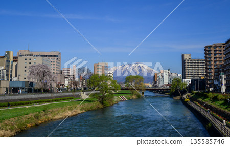 Morioka city overlooking snow-covered Mount Iwaki in Tohoku, Japan. Morioka city overlooking snow-covered Mount Iwaki in Tohoku, Japan. 135585746