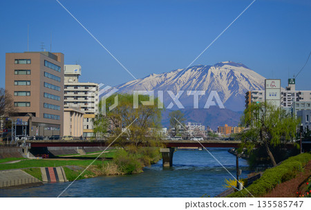 Morioka city overlooking snow-covered Mount Iwaki in Tohoku, Japan. Morioka city overlooking snow-covered Mount Iwaki in Tohoku, Japan. 135585747