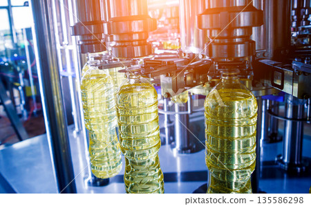 Bottling line of sunflower oil in bottles. Vegetable oil production plant Bottling line of sunflower oil in bottles. Vegetable oil production plant 135586298