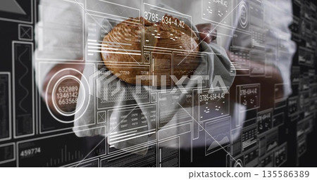 Holding loaf of bread, man in grey vest interacting with holographic data panels at modern office Holding loaf of bread, man in grey vest interacting with holographic data panels at modern office 135586389