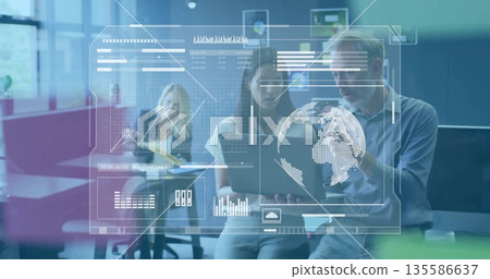 Two coworkers viewing laptop charts and data view in open-plan office with sticky note board Two coworkers viewing laptop charts and data view in open-plan office with sticky note board 135586637